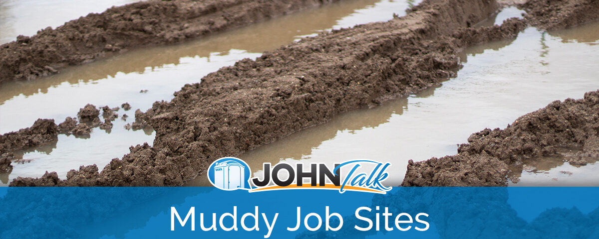 Closeup of muddy tire tracks and water at a job site