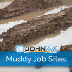 Closeup of muddy tire tracks and water at a job site
