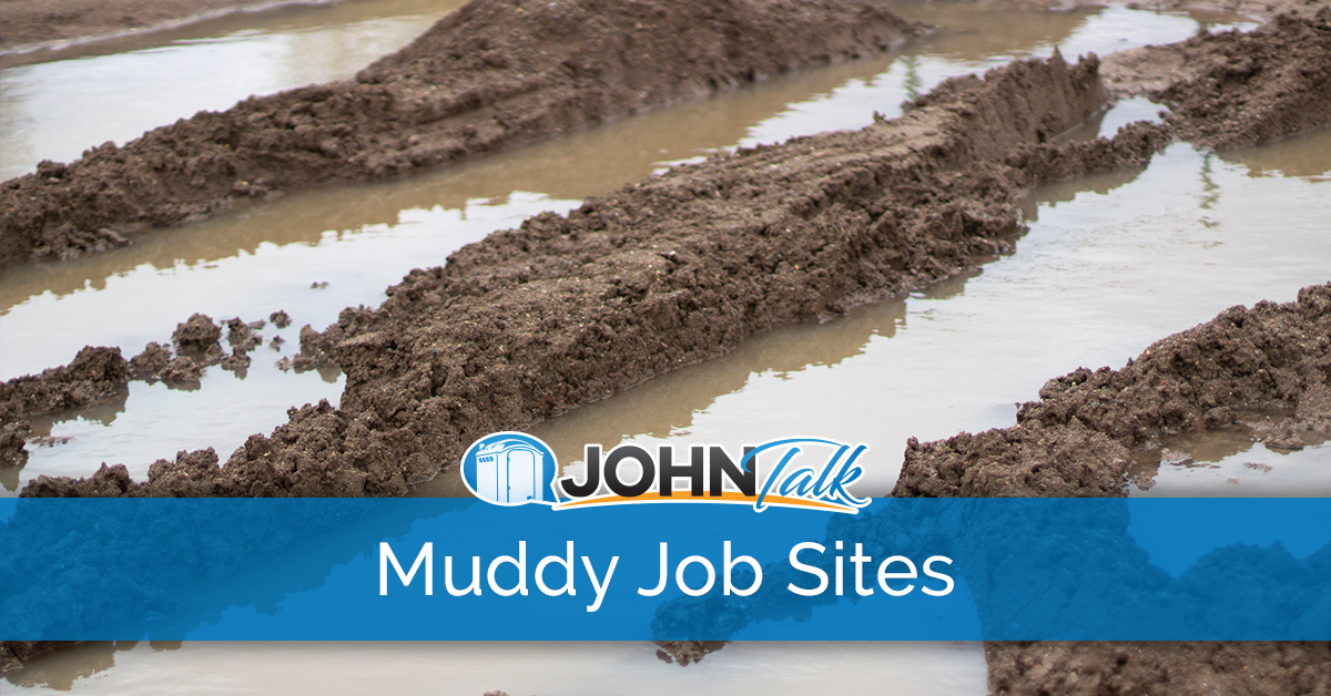 Closeup of muddy tire tracks and water at a job site