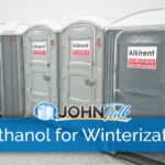 A row of gray portable toilets on a snowy day