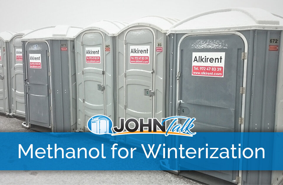 A row of gray portable toilets on a snowy day