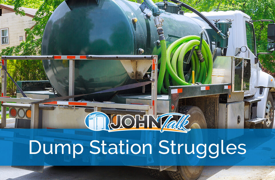 A white truck with a green portable toilet/septic pumping tank and green hose