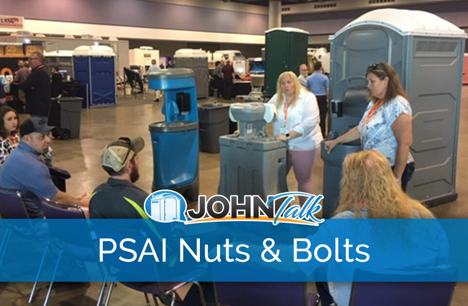 Speakers presenting to tradeshow attendees with portable sanitation products in the background