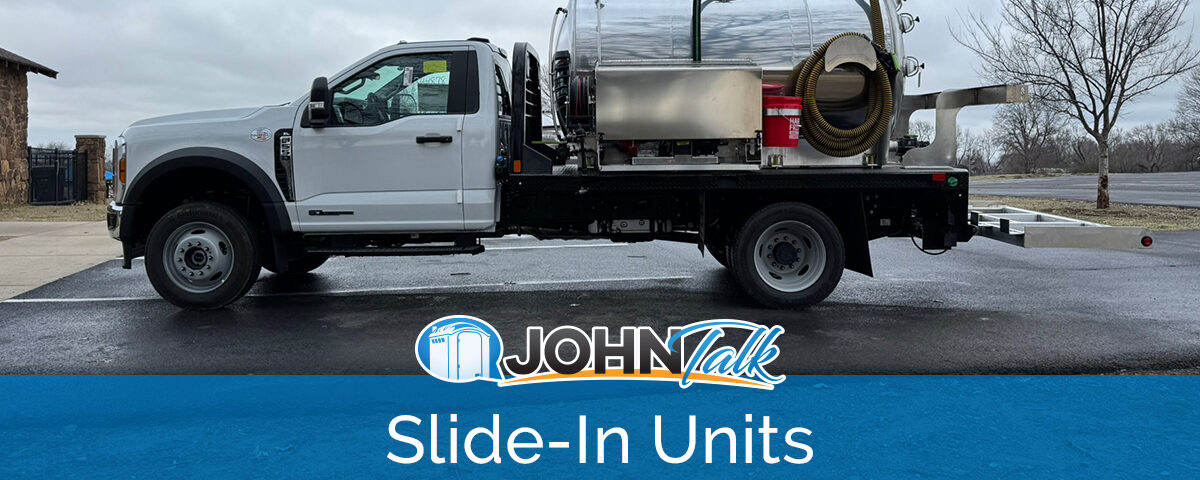A white truck with a slide-in vacuum pump unit in the back