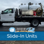 A white truck with a slide-in vacuum pump unit in the back
